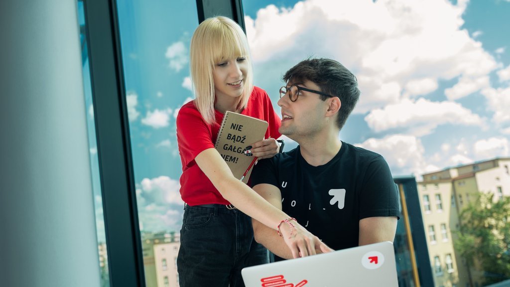 dziewczyna i chłopak siedzą przy laptopie