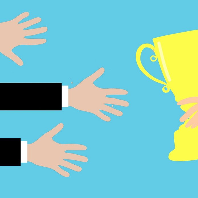 puchar i ręce wyciągające się po niego