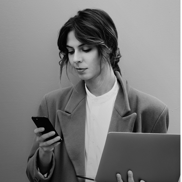 młoda kobieta spoglądająca na trzymany w dłoni telefon