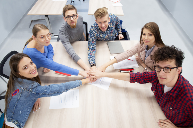 Grupa studentów trzyma się za ręce w znaku jedności