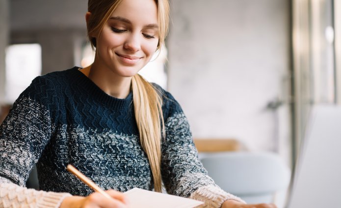 a decorative element: a girl taking notes in front of the computer