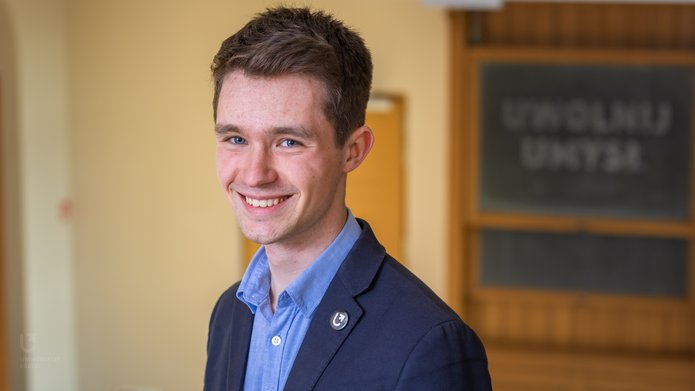 A smiling young student, graduate of the programme