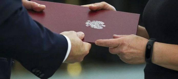hands handing over a diploma