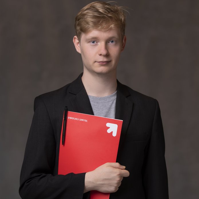 Młody mężcyzna trzymający teczkę papierową z napisem Uwolnij umysł