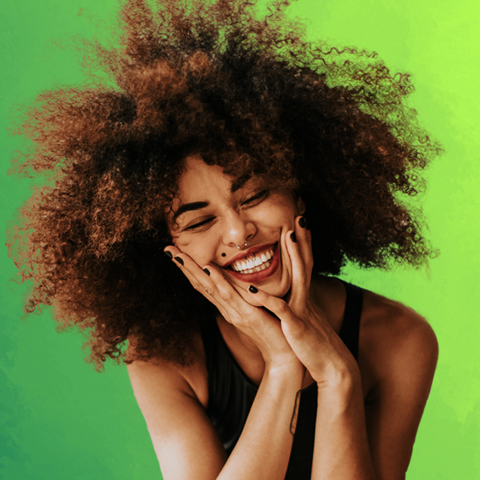 uśmiechnięta młoda kobieta na zielonym tle